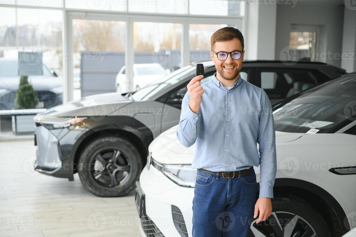 Concept of buying electric vehicle. Handsome business man stands near electric car at dealership photo