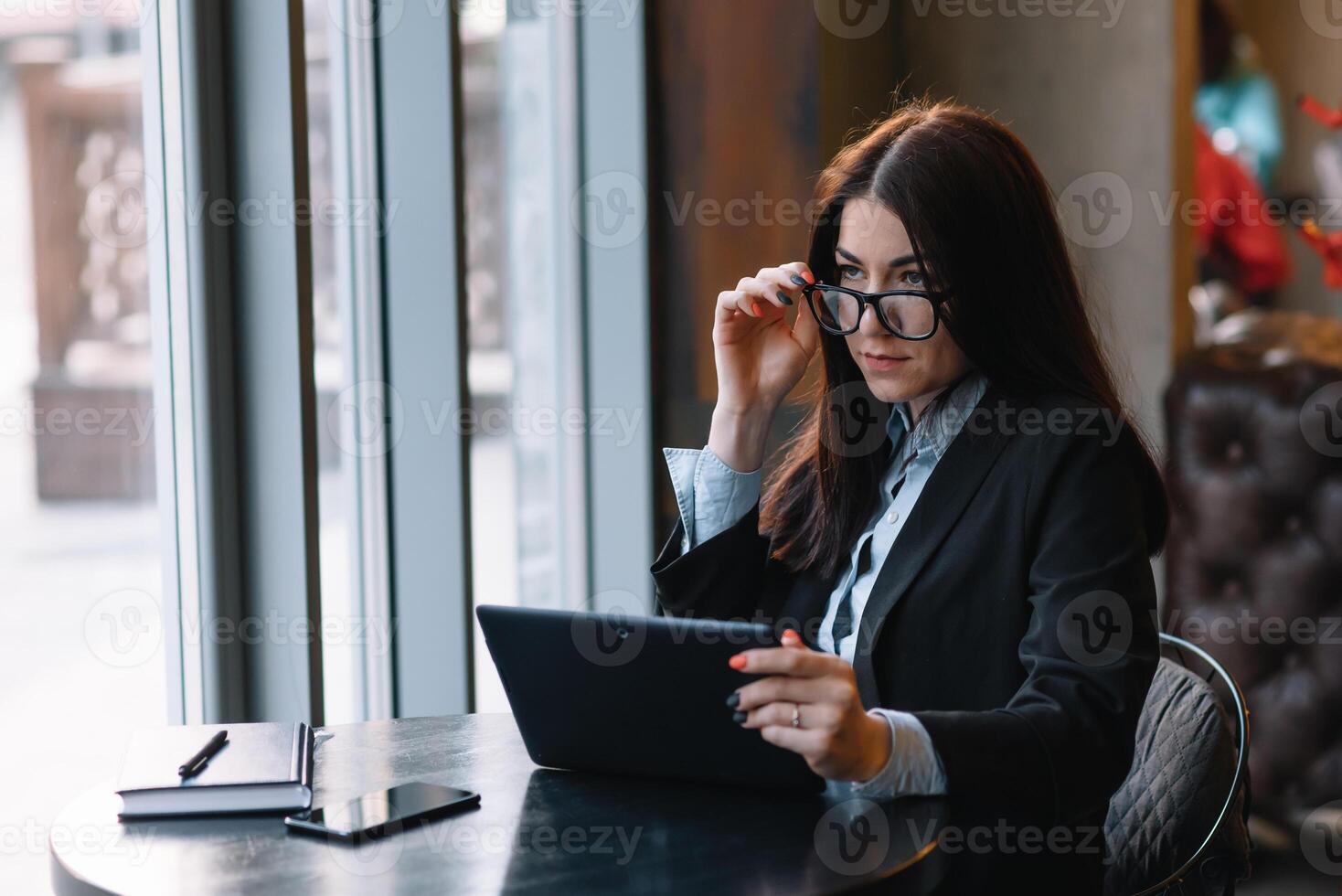 Happy young businesswoman using tablet computer in a cafe. Selective focus photo