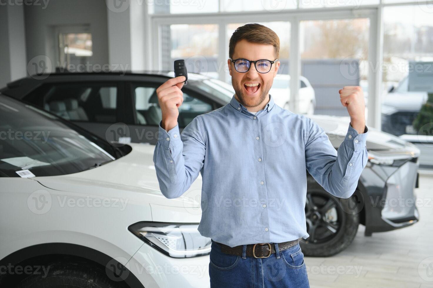 Young man buying first electric car in the showroom. Eco car sale concept photo