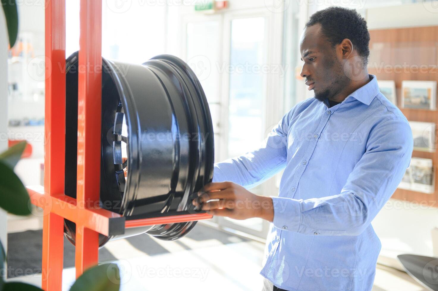 An African man buys car rims in an auto parts store photo