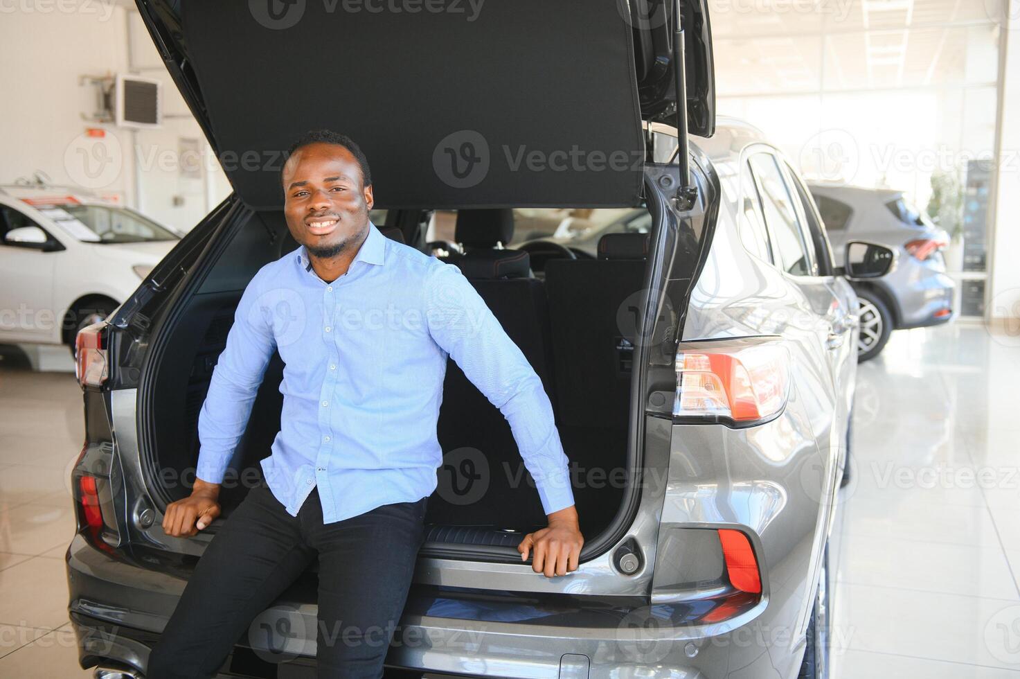 Handsome man is standing near his new car and smiling photo