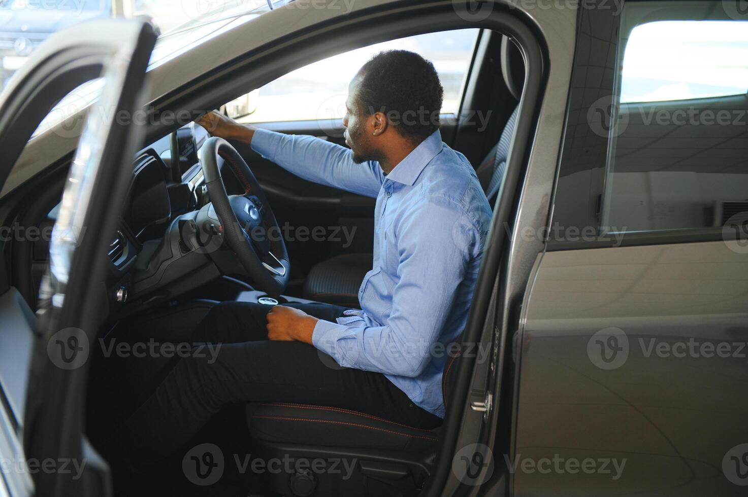 Car Owner. Joyful Afro Guy Smiling, Sitting In New Automobile Driving From Dealership Shop photo