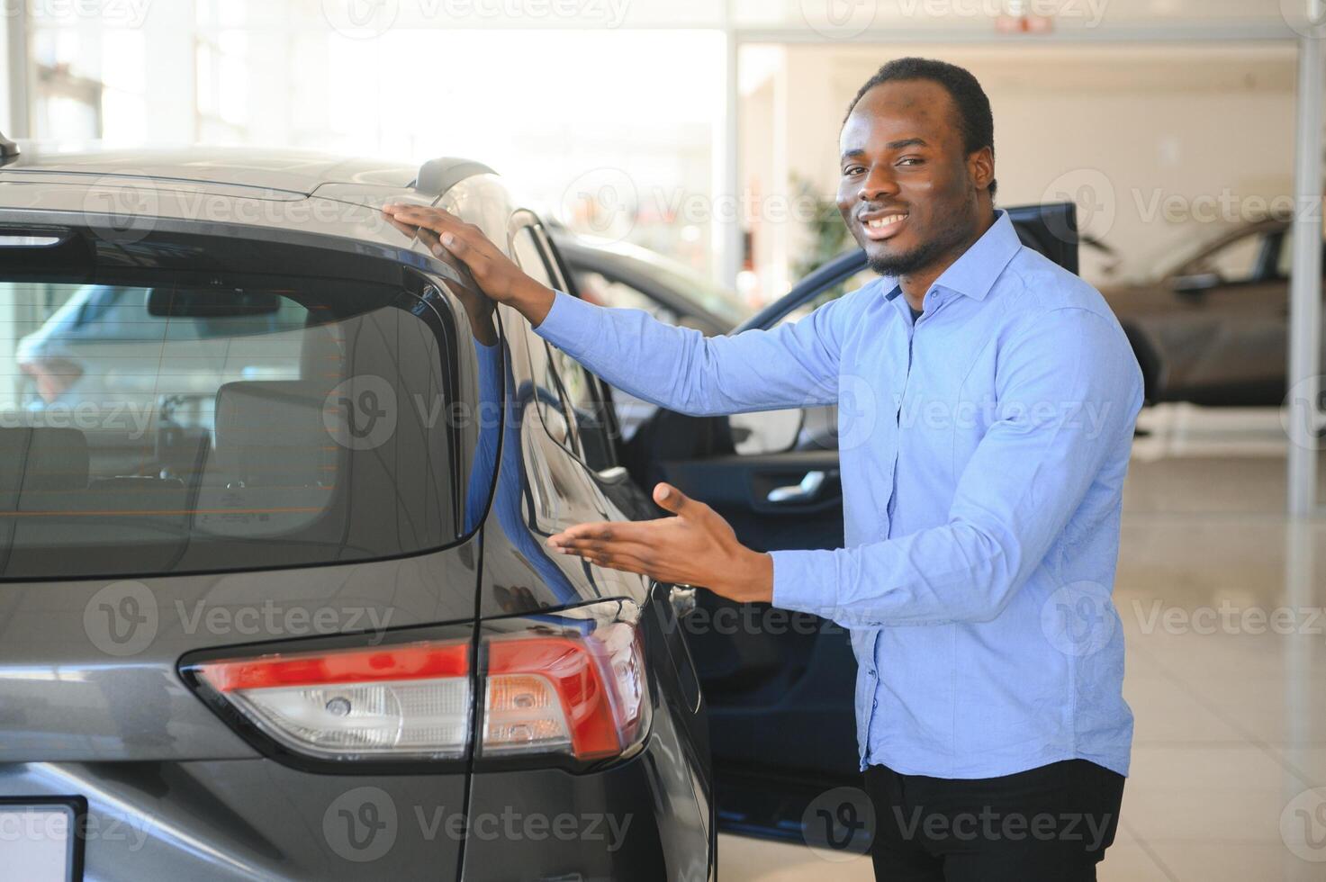 hermoso hombre es en pie cerca su nuevo coche y sonriente foto