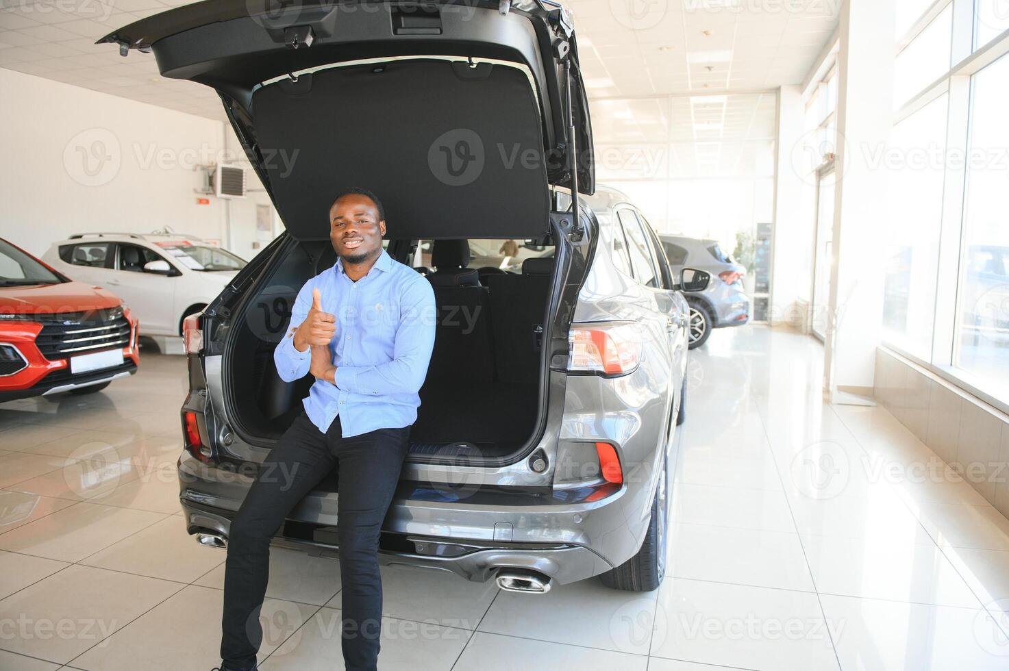 coche comprador. negro chico elegir nuevo automóvil en concesión Tienda foto