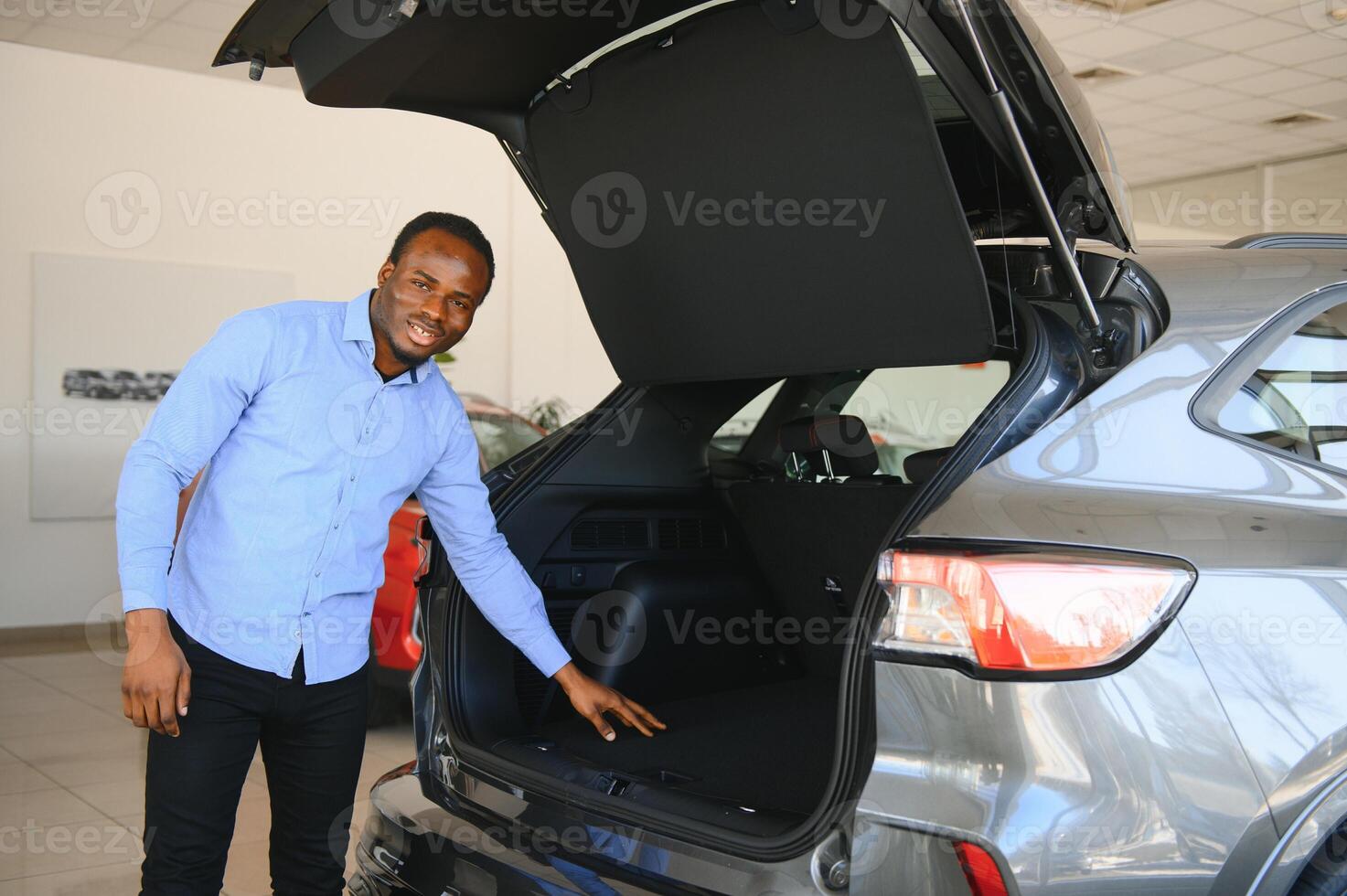 Handsome African man choosing a new car at the dealership photo