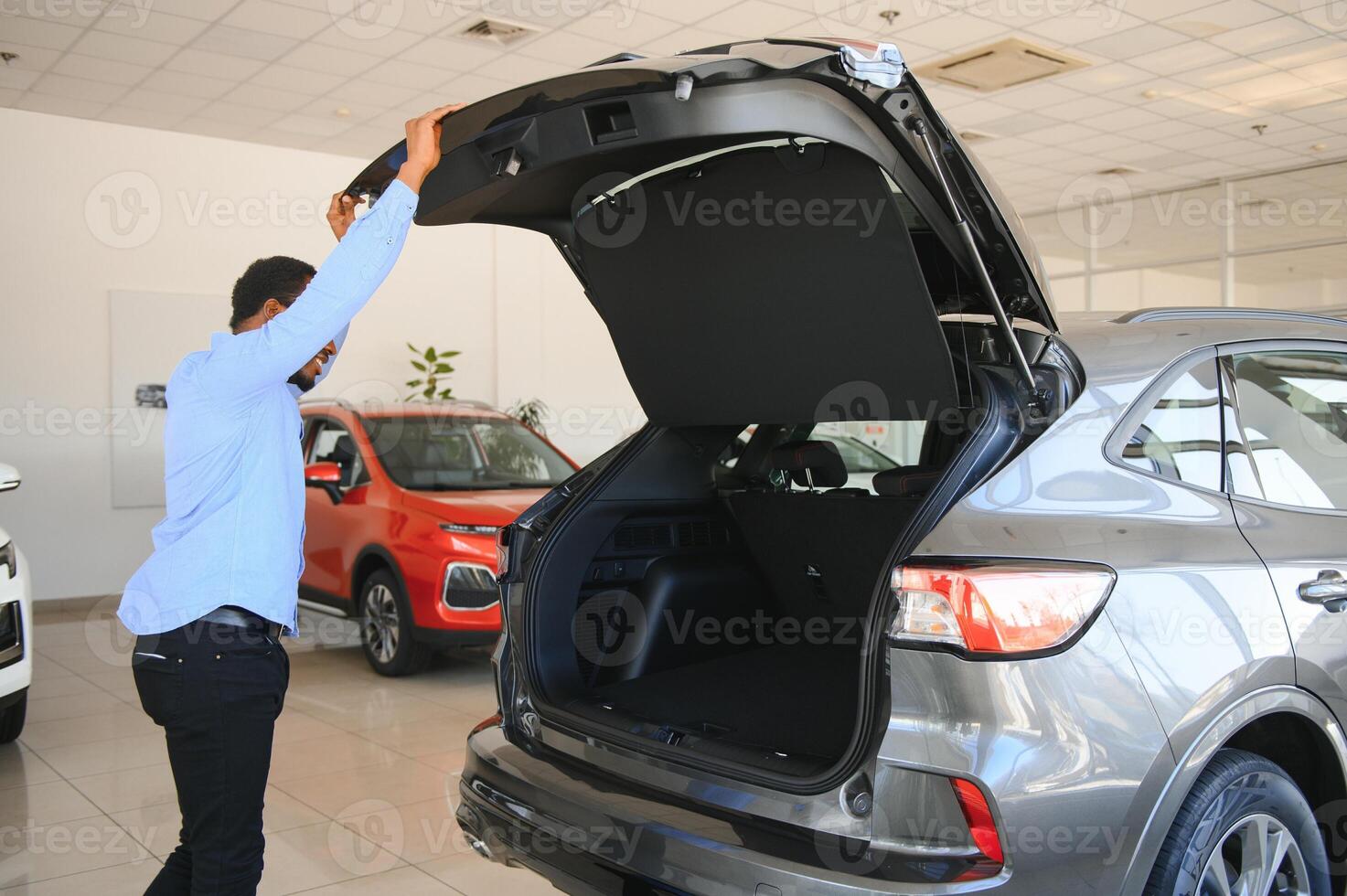 coche comprador. negro chico elegir nuevo automóvil en concesión Tienda foto