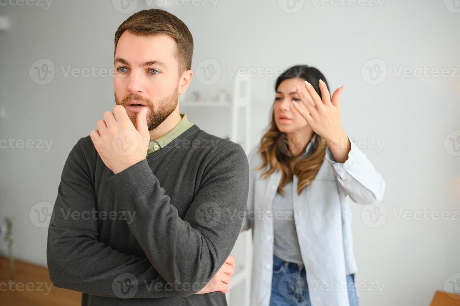 Family quarrel, man and woman sitting on sofa at home. angry woman yells at her husband photo