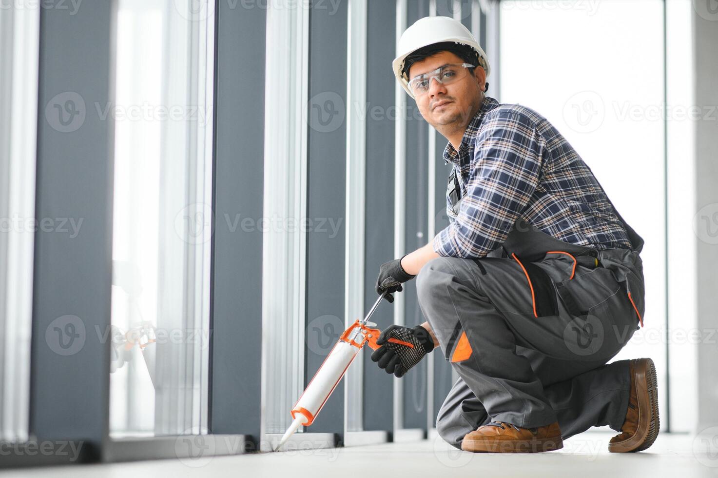 el trabajador instala un ventana marco en el habitación foto