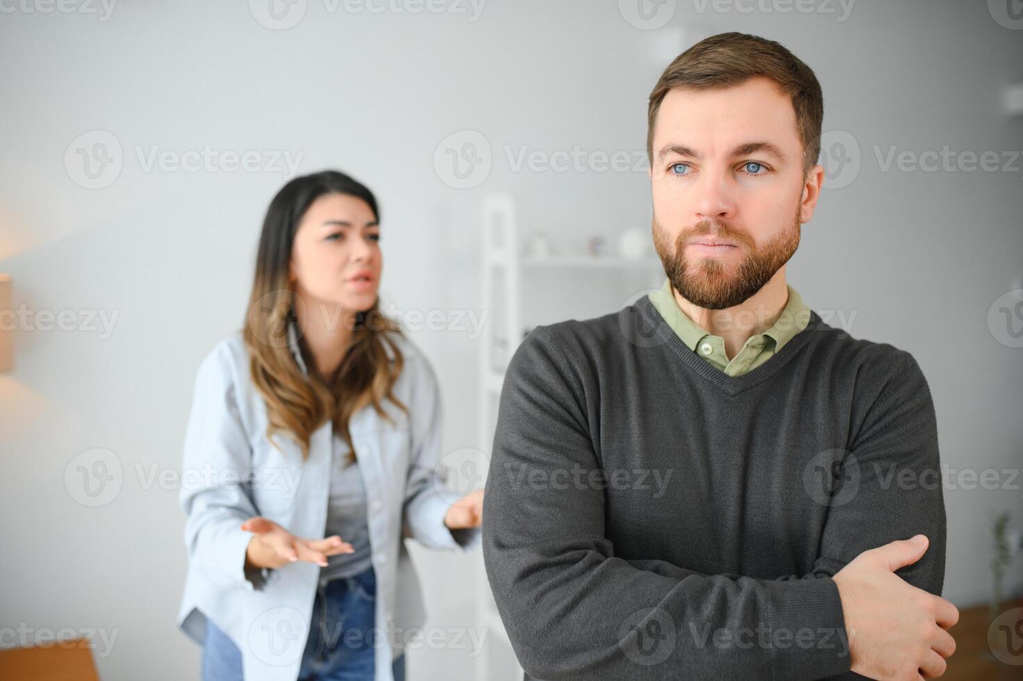 Family quarrel, man and woman sitting on sofa at home. angry woman yells at her husband photo