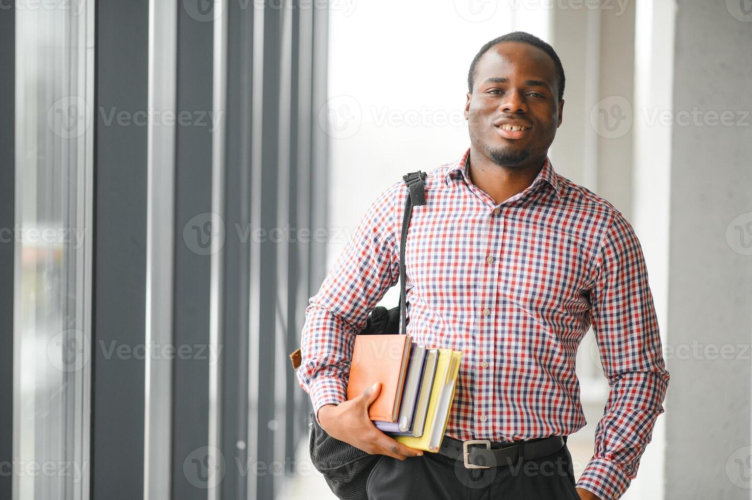 handsome college boy holding books on campus photo