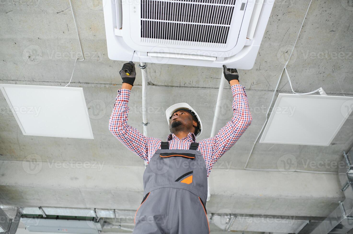 african Male Technician Repairing Air Conditioner. photo