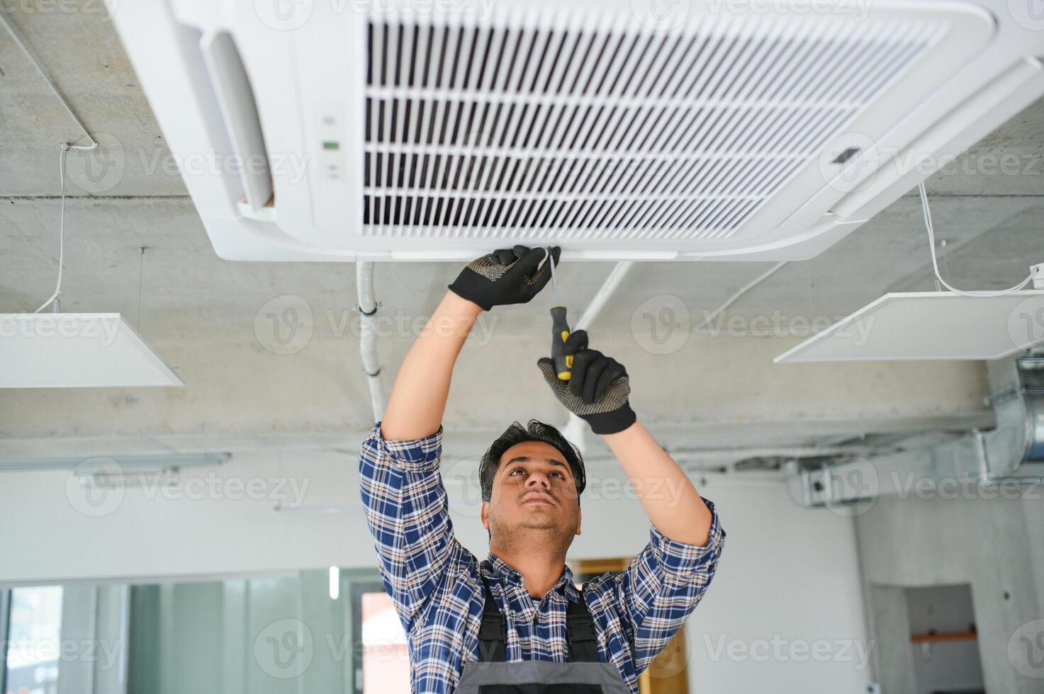 specialist cleans and repairs the wall air conditioner photo