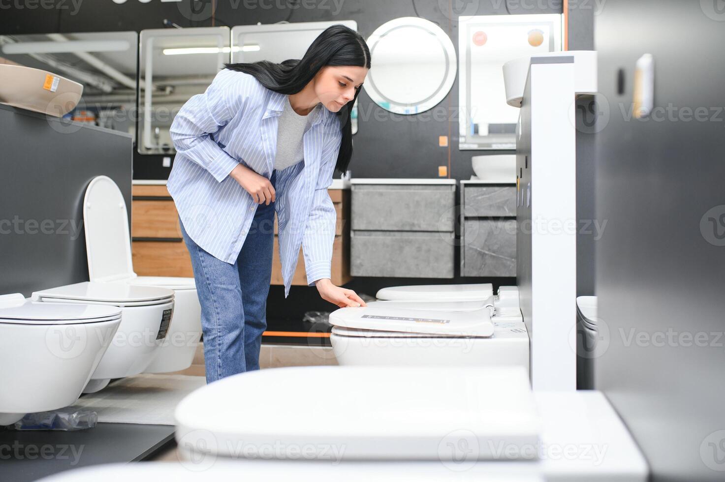 Young woman choosing bathroom toilet bowl and utensils for his home photo