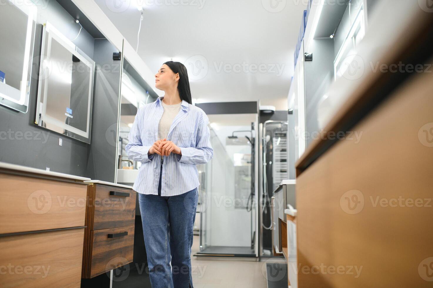 Woman chooses a mirror at home in a store photo