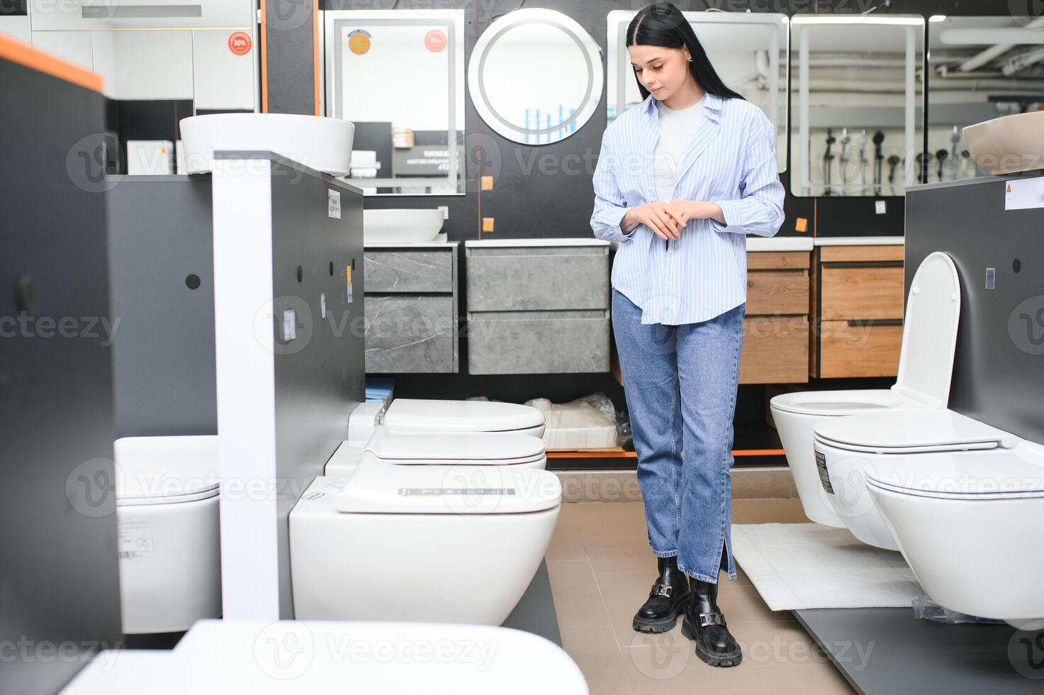 Young woman choosing bathroom toilet bowl and utensils for his home photo