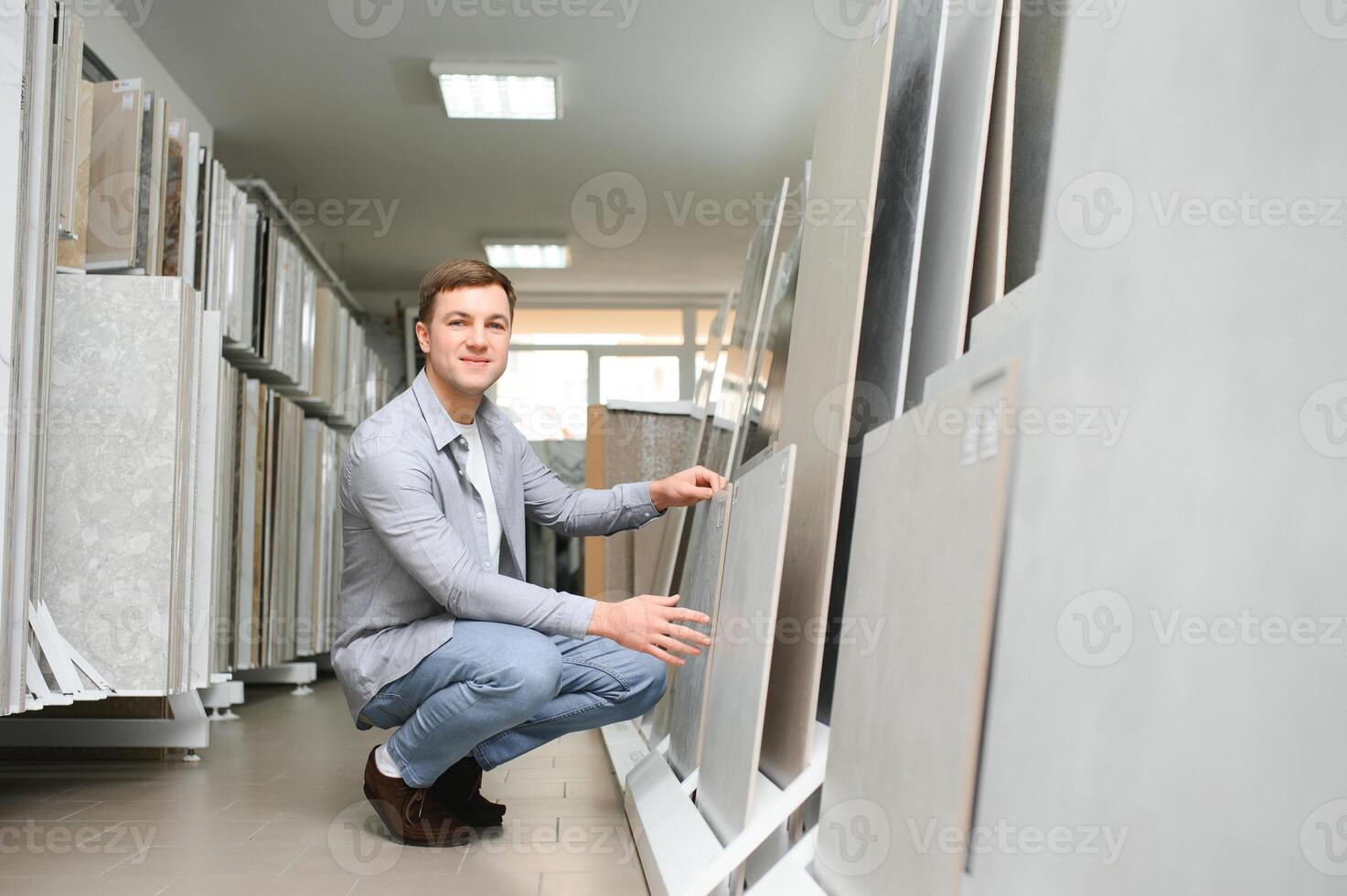 Male architect or interior designer choosing ceramic texture sample from swatch board in design studio photo