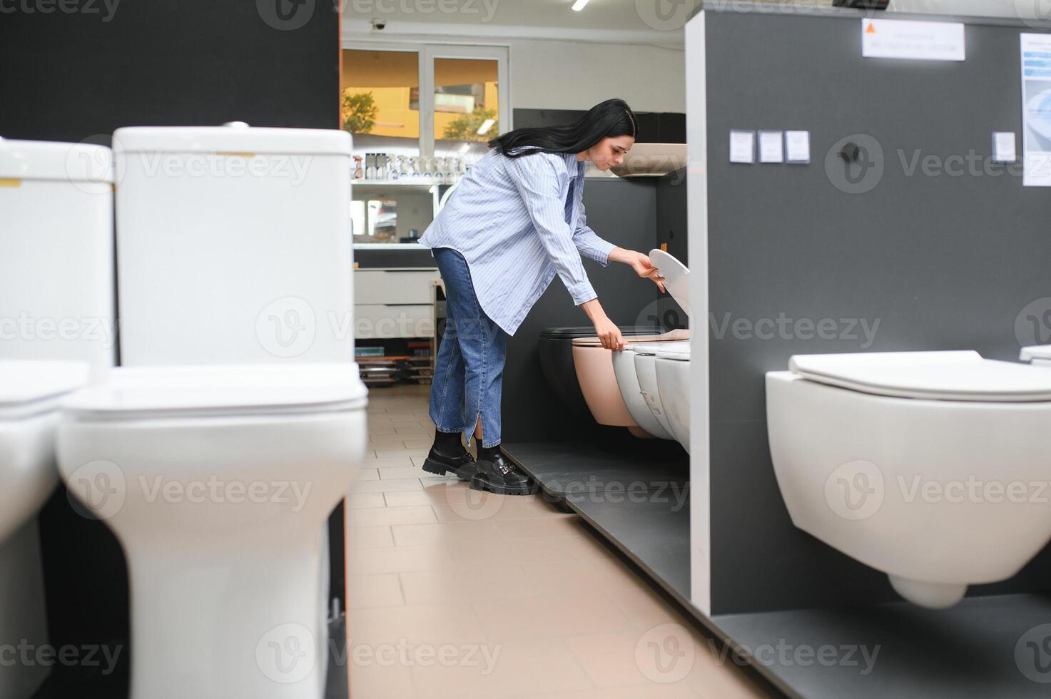 Woman choosing home toilet in store photo