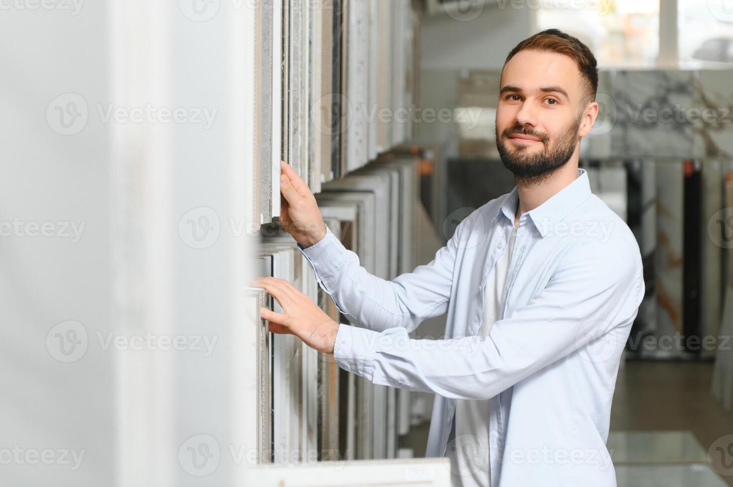 man choosing ceramic tiles and utensils for his home bathroom photo