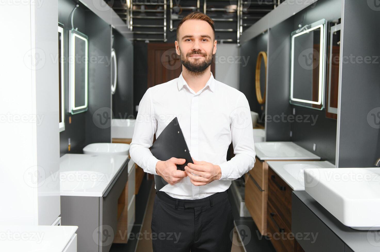 Happy salesman plumber man with paper tablet on plumbing shop photo