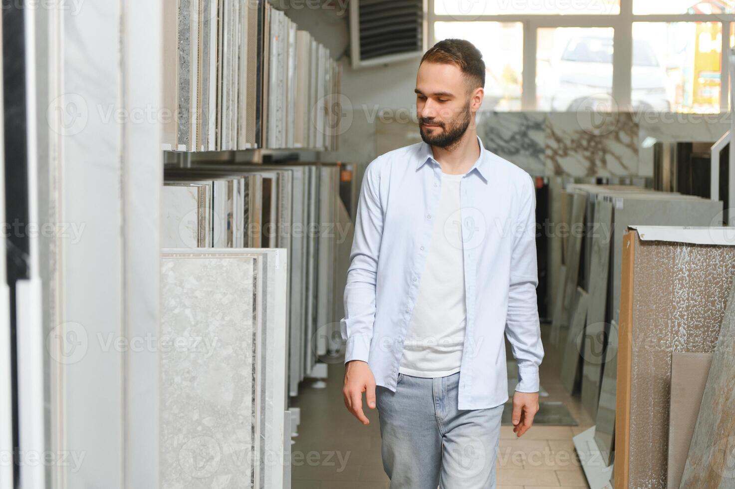 man choosing ceramic tiles and utensils for his home bathroom photo