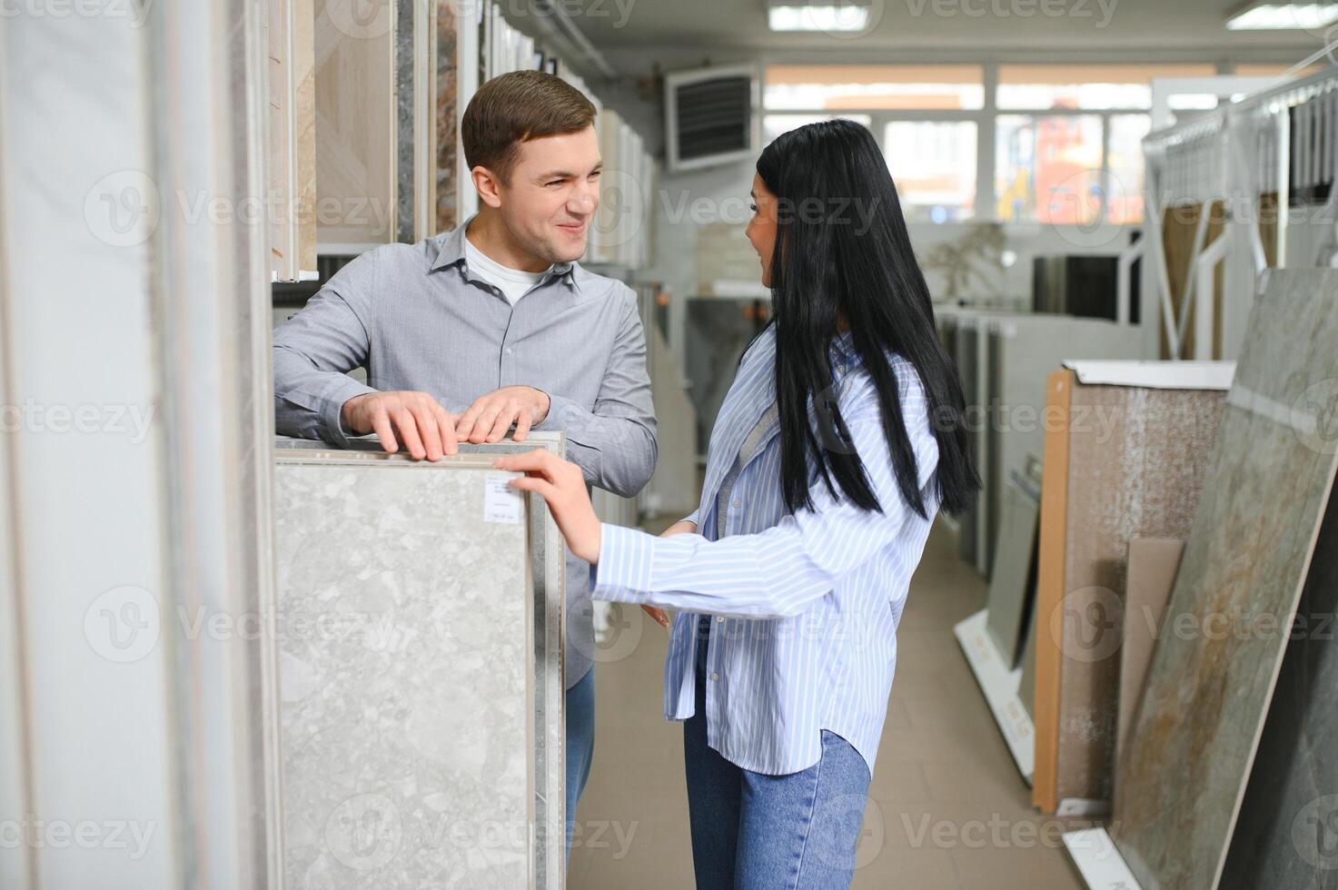 Beautiful young couple choosing ceramic tiles photo