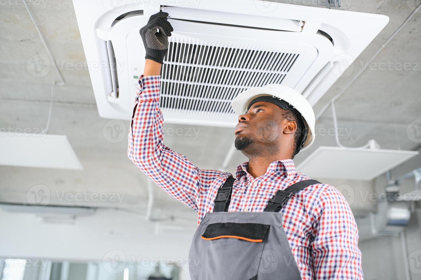 african Male Technician Repairing Air Conditioner. photo