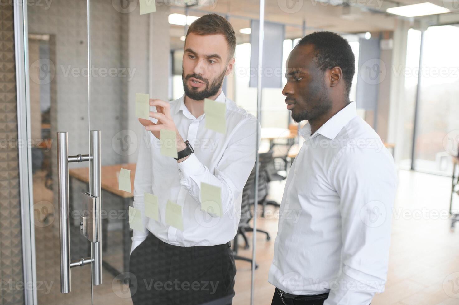 Young businessman manager writing strategy ideas on sticky notes. Business project planning. photo