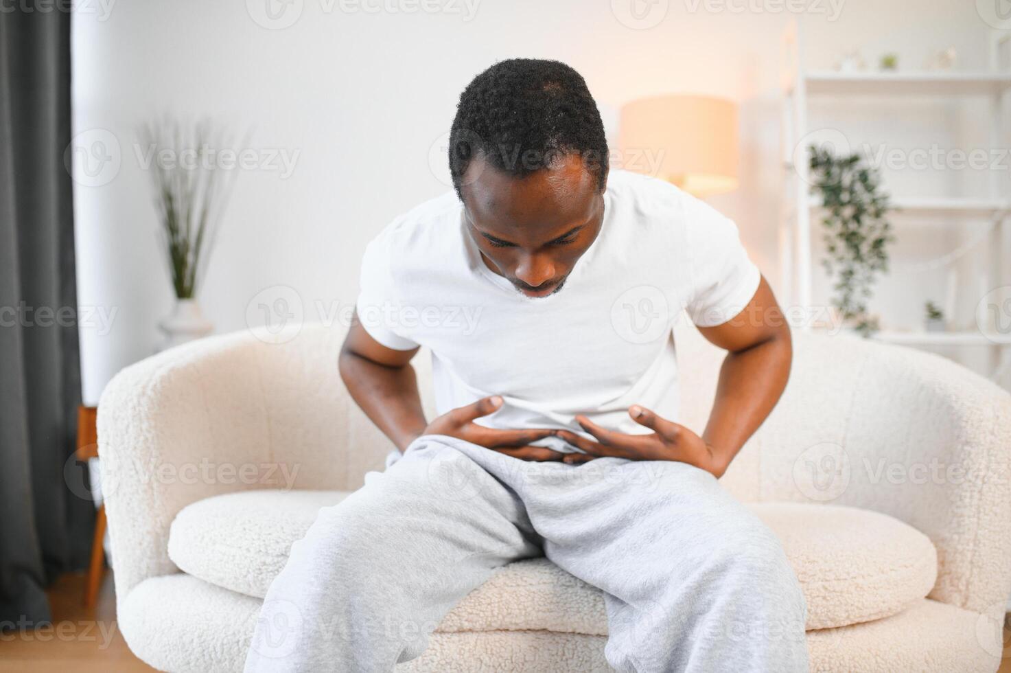 Black Man Having Stomachache Suffering From Painful Abdominal Spasm Standing Touching Aching Abdomen At Home photo