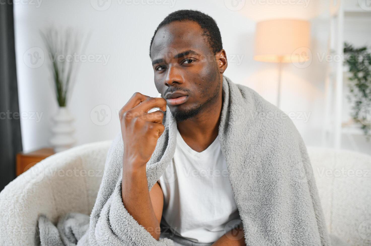 Shot of a young man with a cold recuperating at home photo