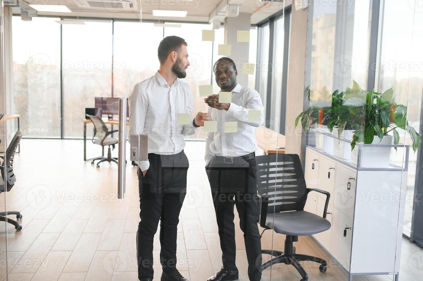 Young businessman manager writing strategy ideas on sticky notes. Business project planning. photo