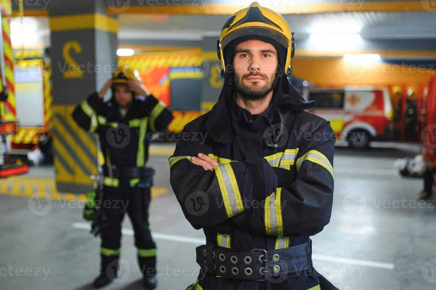 Group of firefighters at the emergency vehicle in the fire station photo