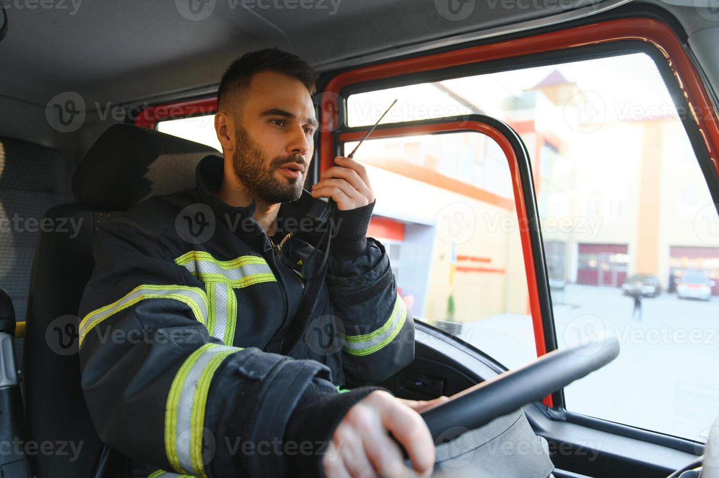 Firefighter using radio set while driving fire truck photo