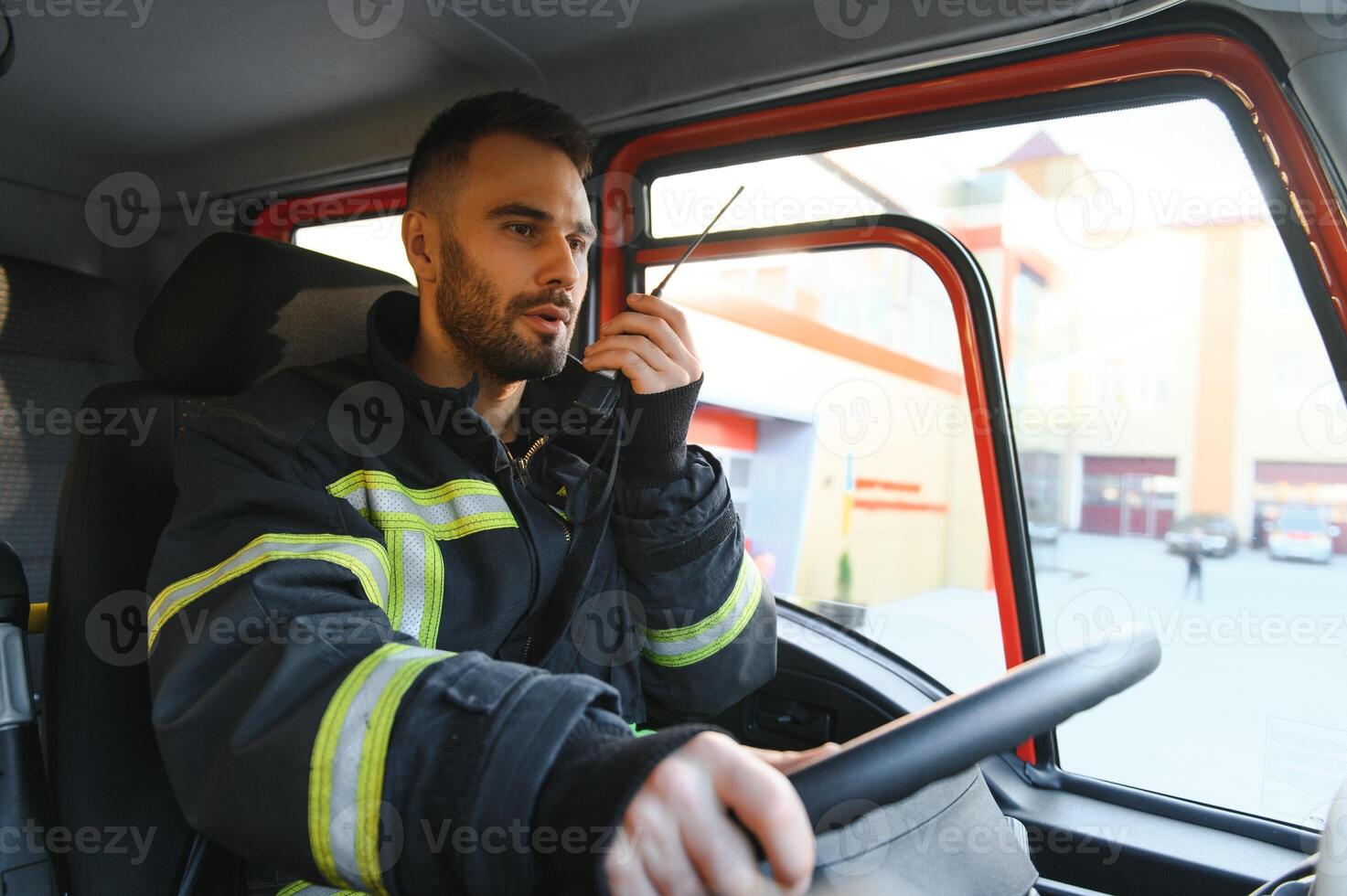 bombero utilizando radio conjunto mientras conducción fuego camión foto