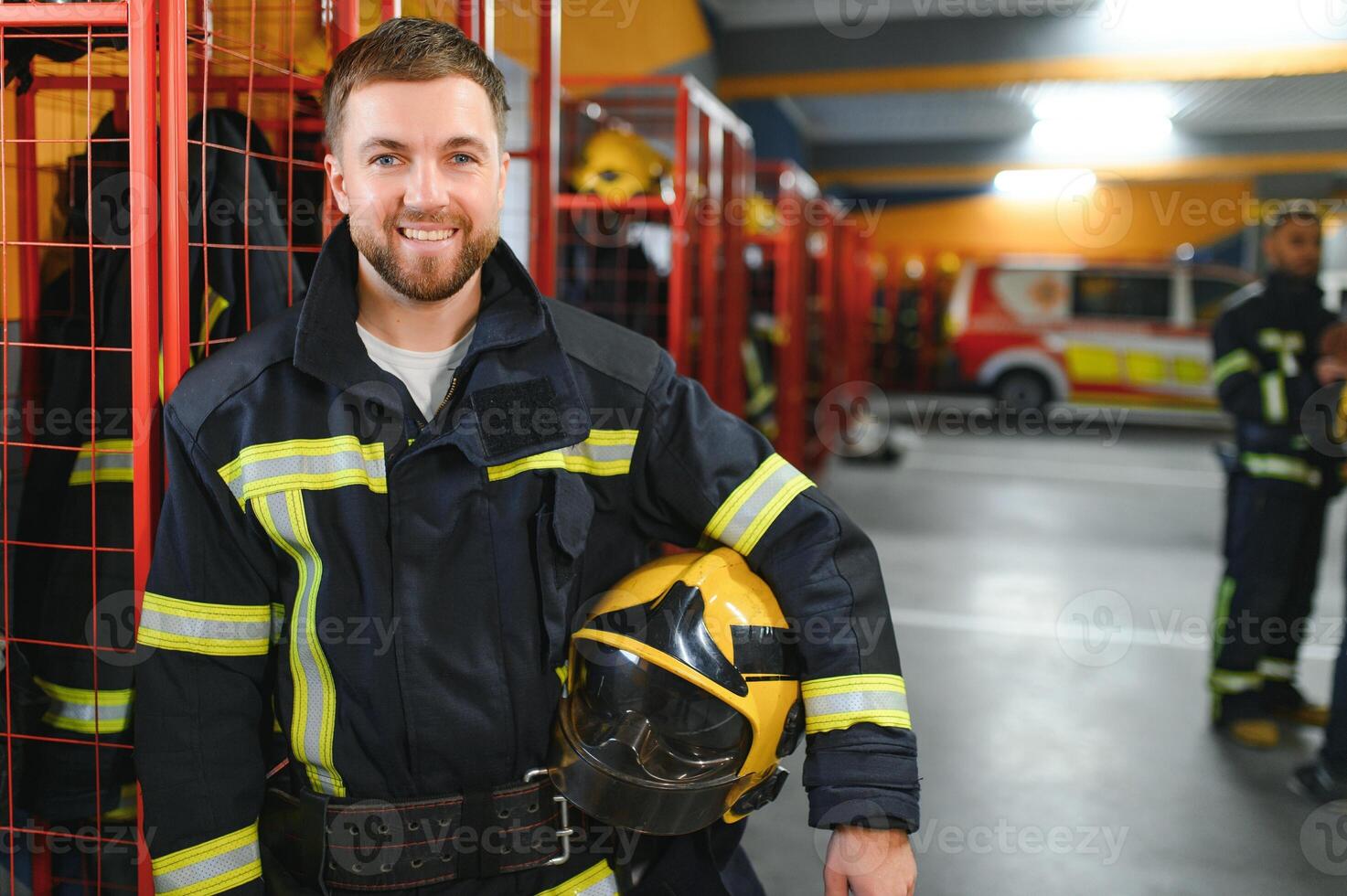Fireman wearing protective uniform standing in fire department at fire station photo