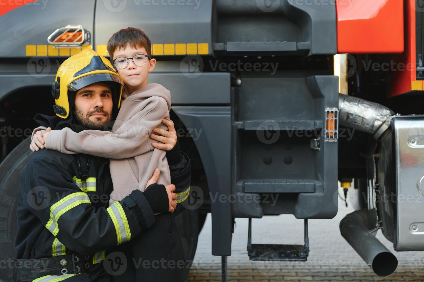 Firefighter holding child boy to save him in fire and smoke,Firemen rescue the boys from fire photo