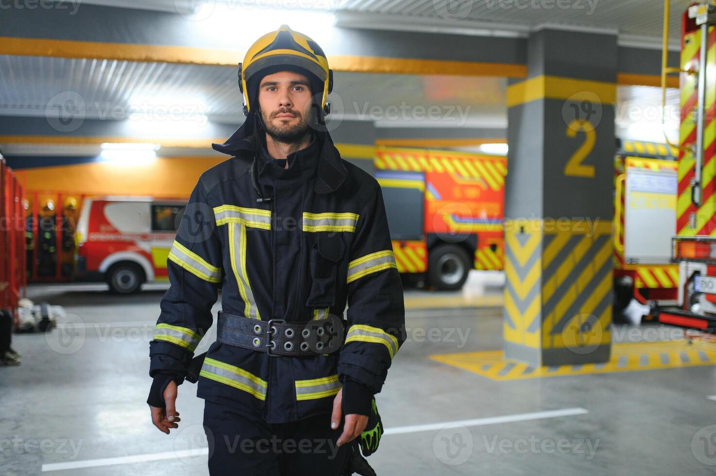 Portrait of male firefighter in uniform at fire station photo