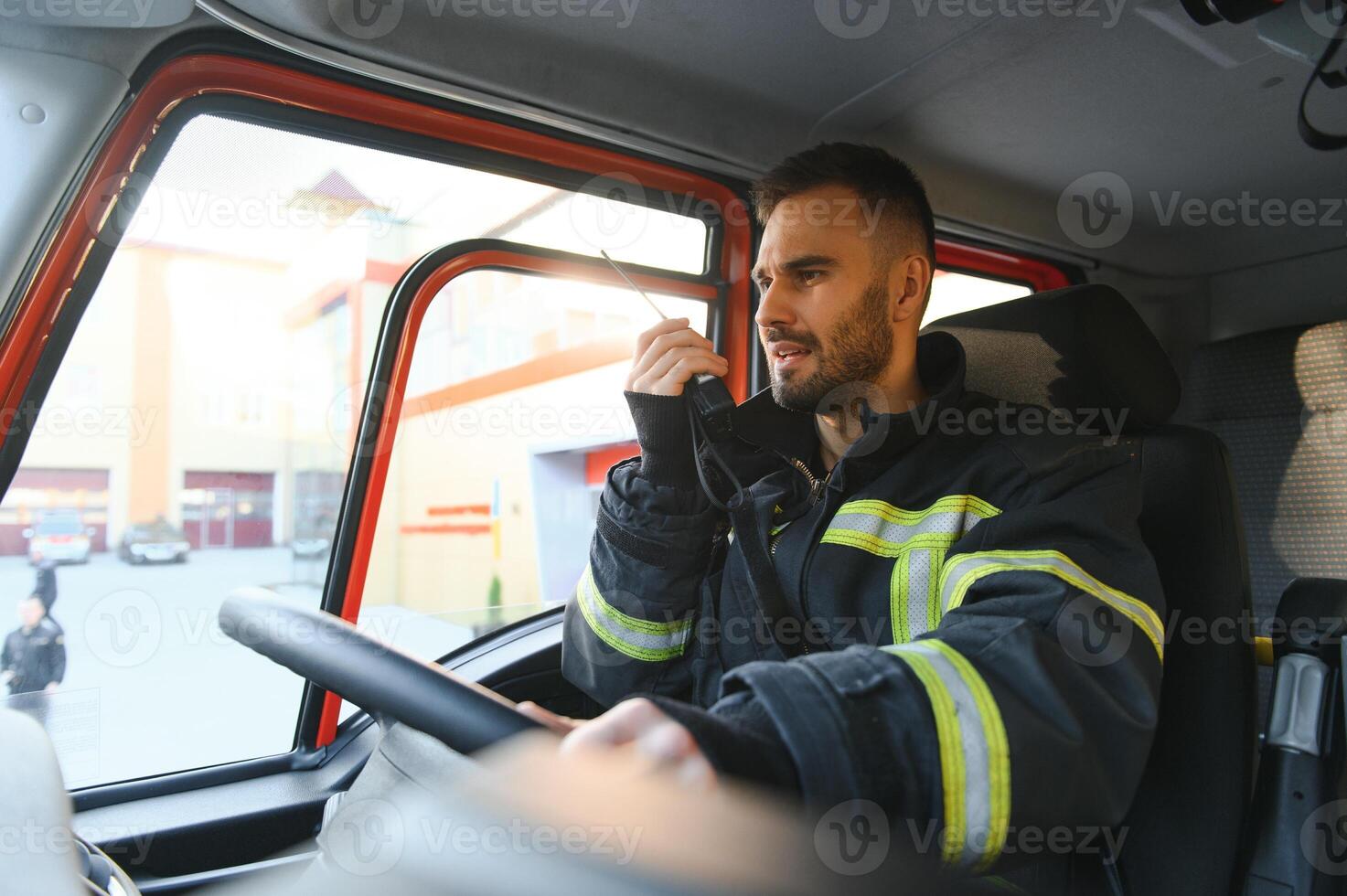bombero utilizando radio conjunto mientras conducción fuego camión foto