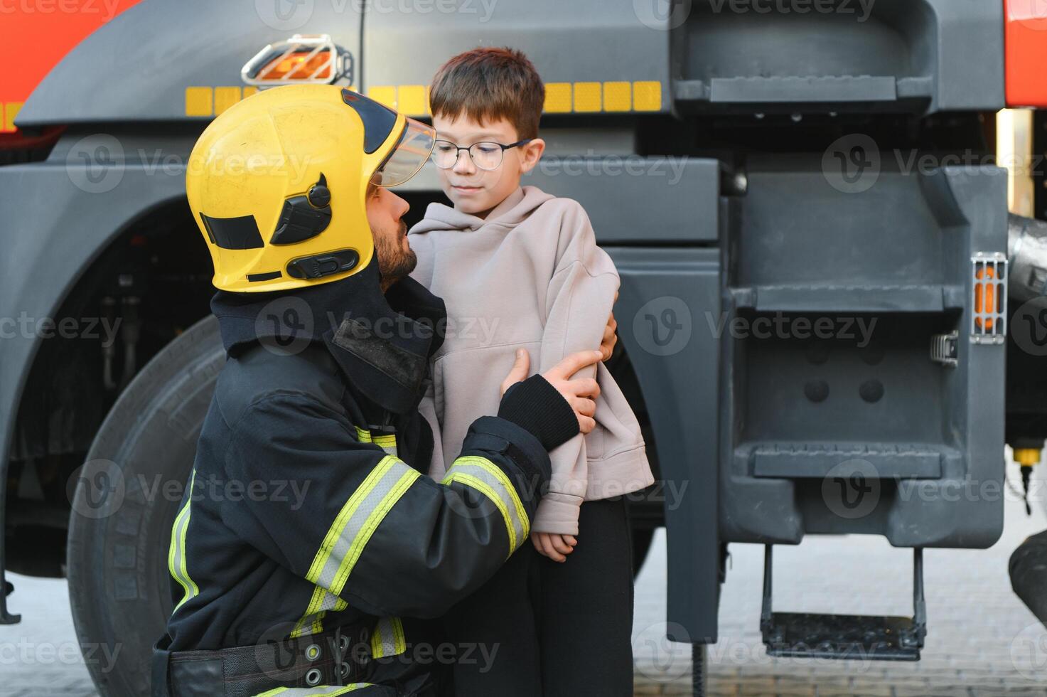 Firefighter holding child boy to save him in fire and smoke,Firemen rescue the boys from fire photo