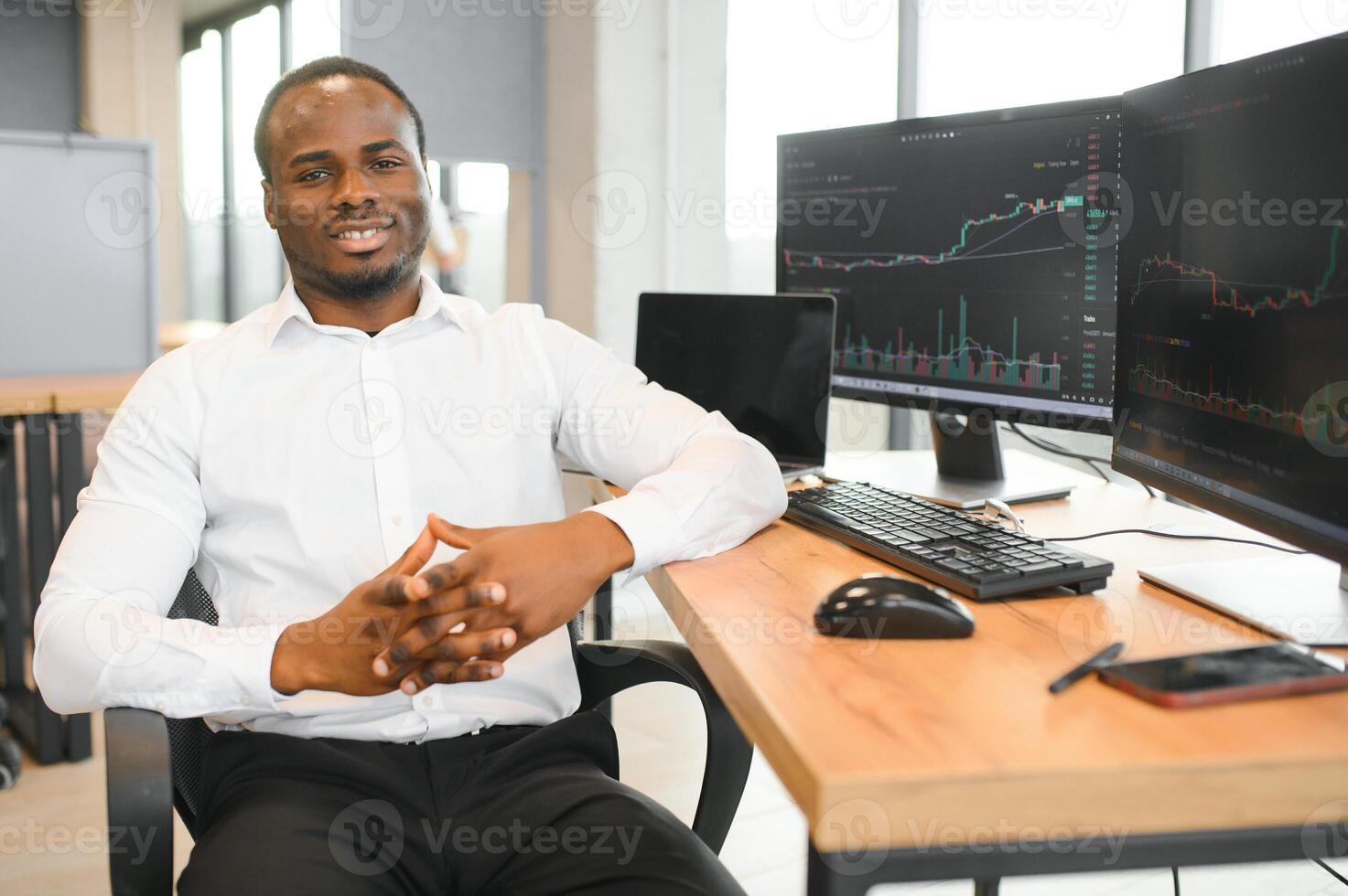 African-American broker works in office using workstation and analysis technology photo
