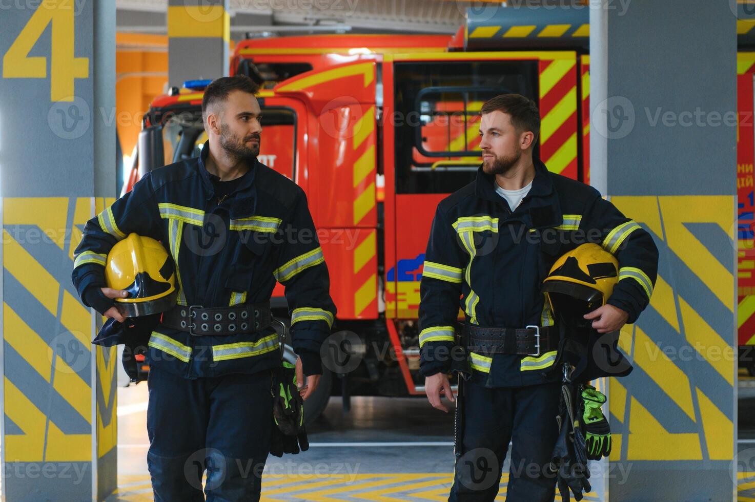 dos bomberos en protector ropa en cascos con fuego motor foto