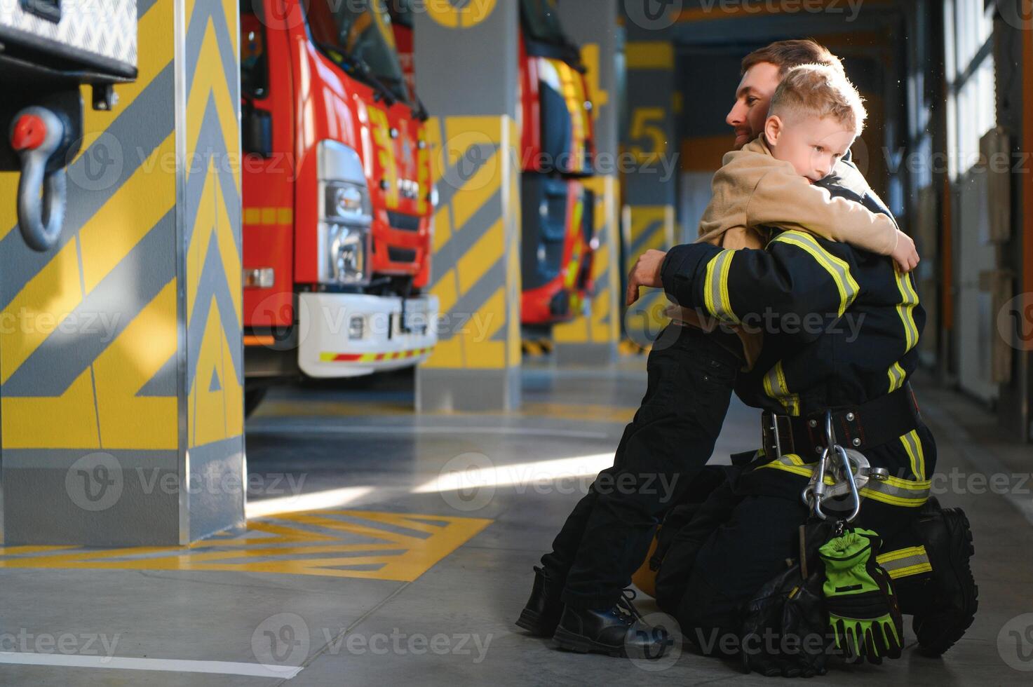 A firefighter take a little child boy to save him. Fire engine car on background photo