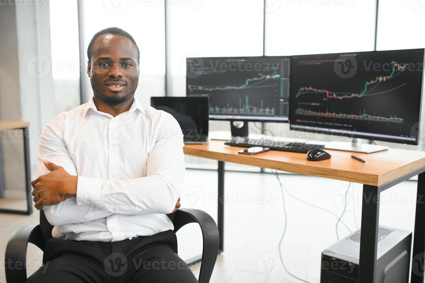 African-American broker works in office using workstation and analysis technology photo