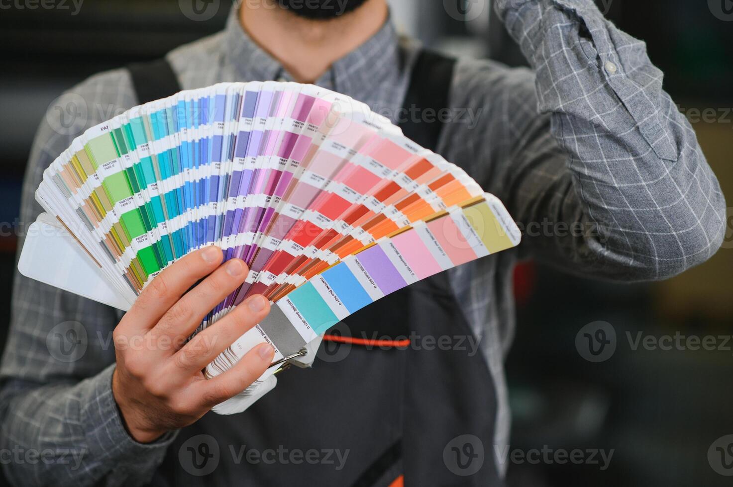 Typographer standing with color swatches at the printing manufacturing photo