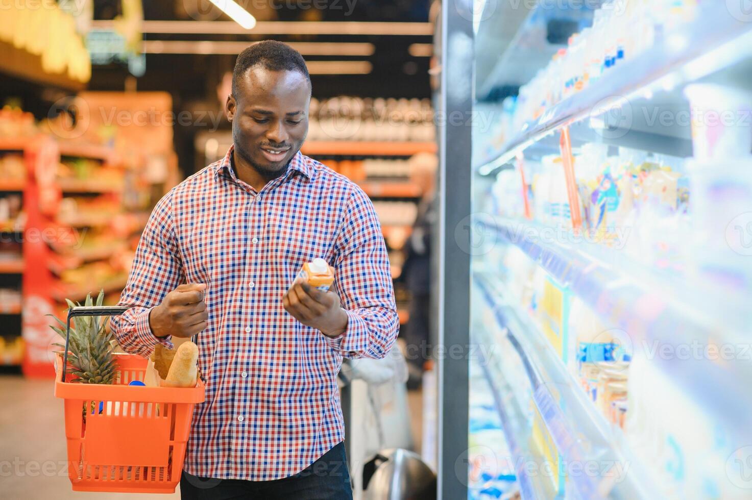 Young african man buying in grocery section at supermarket photo