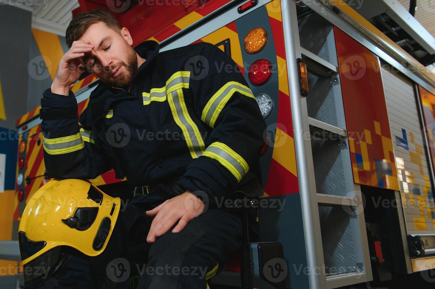 A seated and sweating firefighter is exhausted, distressed and tired after being overwhelmed in a rescue operation photo