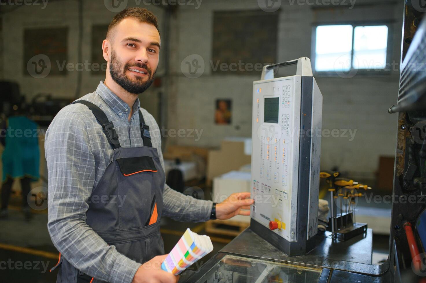 printing house, experimented technician works on UV printer. Production work photo