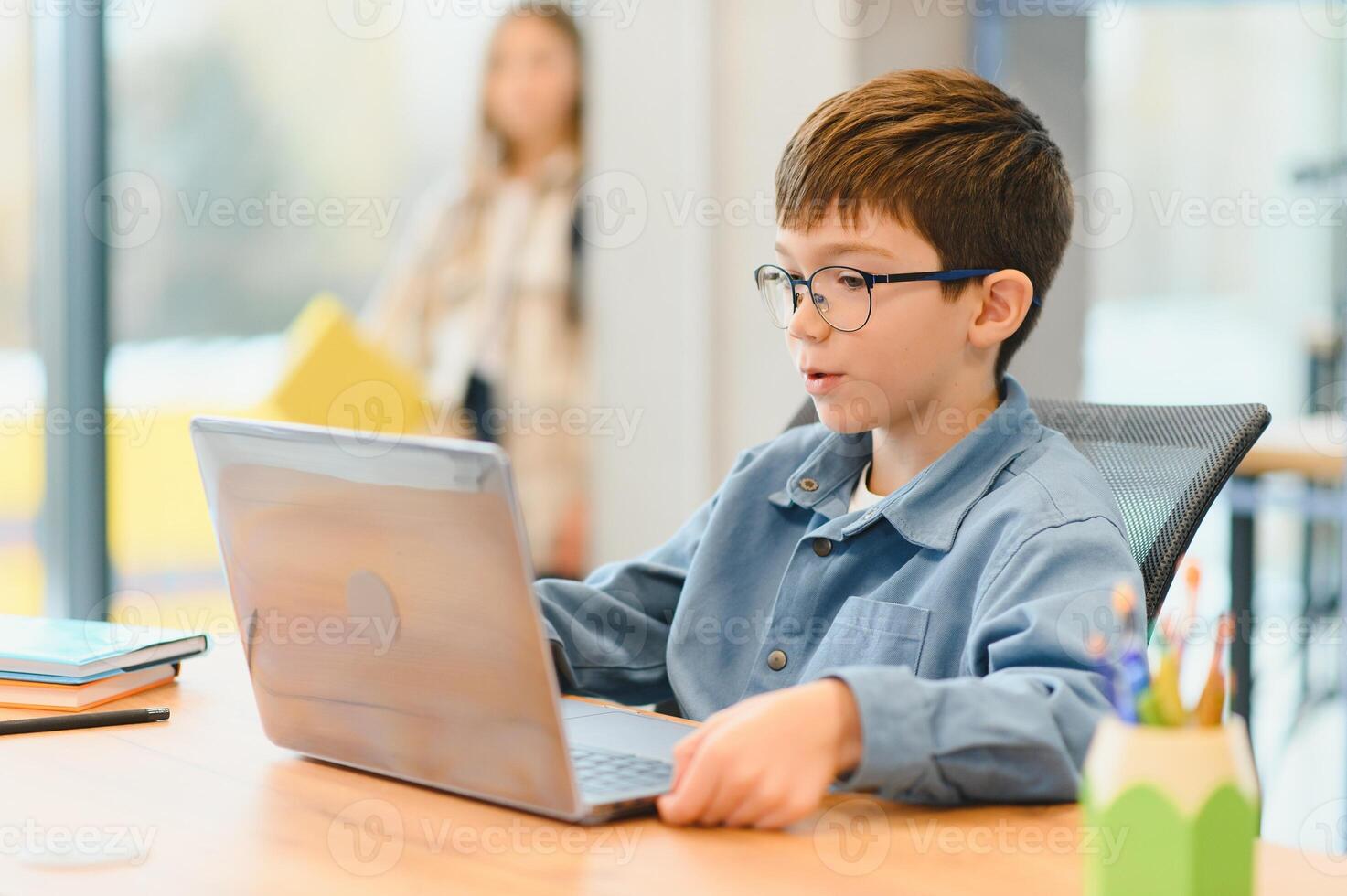 Smiling teen male chatting with friends in social networks sitting front laptop photo