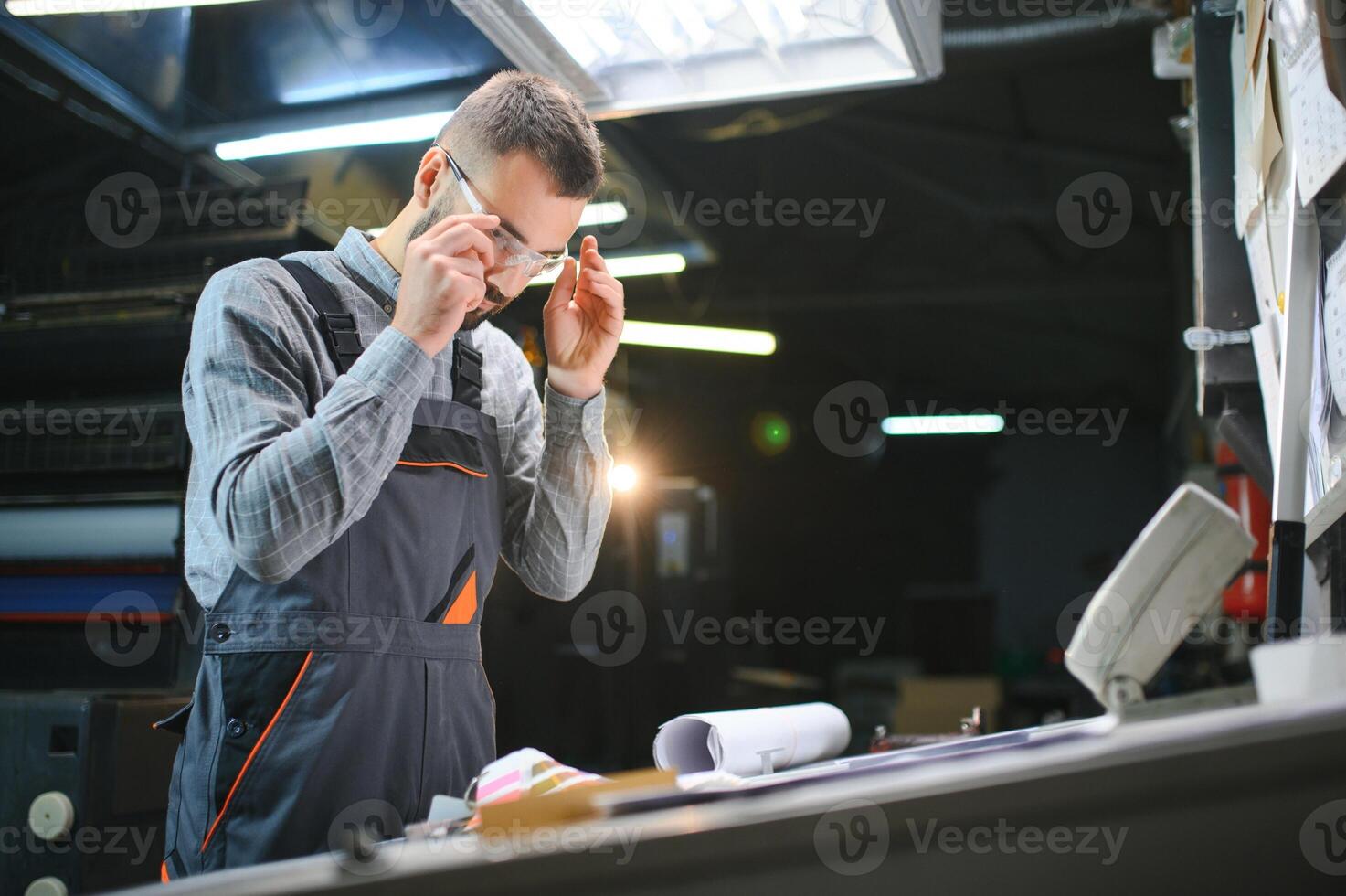 printing house, experimented technician works on UV printer. Production work photo