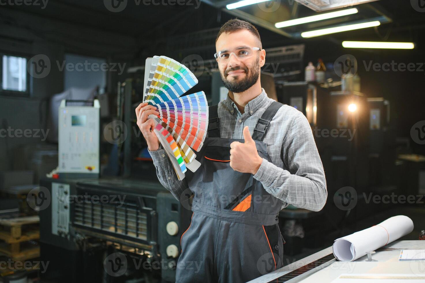 Typographer standing with color swatches at the printing manufacturing photo