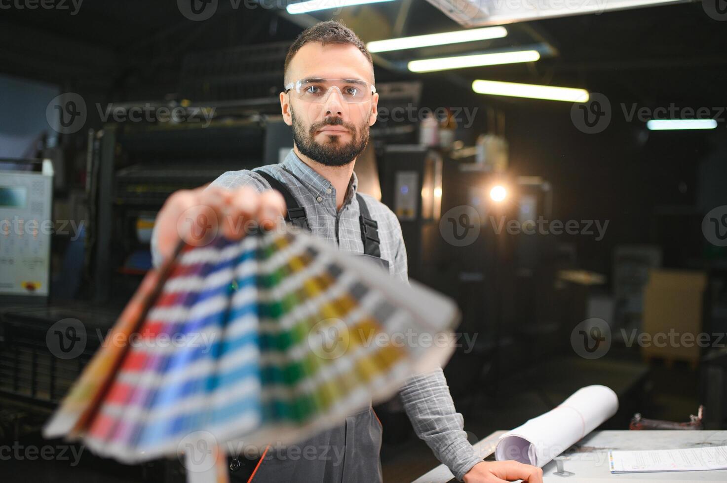 Typographer standing with color swatches at the printing manufacturing photo